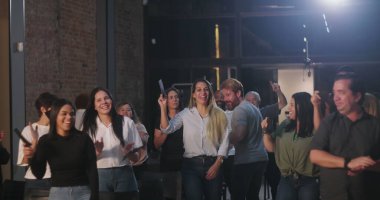 Kiliseye ibadet sırasında bağış kutusuna zarf koyan iki kadın, neşeli ve saygılı ifadeler, ruhani sunuma katılan çeşitli arka planda yer alan farklı topluluk