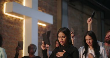 Kilisede ibadet sırasında çeşitli cemaatlerin bağış toplaması, tuğla duvarda aydınlatılmış haç, ruhani birlik, duacı toplantı, inanç ve bağlılığın sembolik hareketi.