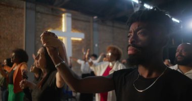 İbadet sırasında el ele tutuşan, birlik ve inancı ifade eden, maneviyatı ve cemaati sembolize eden, içten bir kilise ayini yapan insanlar.