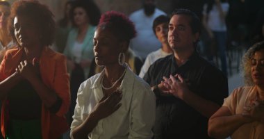 Evanjelist kilise toplantısı sırasında yürekten ibadet eden cemaat, Afrika kökenli vaiz ilham verici bir mesaj, manevi birlik ve bağlılık iletiyor.