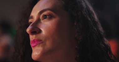 Uzağa dikkatlice bakan bir kadın, yumuşak bir ifadeyle yan profili, derin bir odak ve tefekkür yakalıyor.