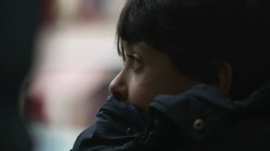 Yakından bakınca, çenesini cekete dayamış, düşünceli bir ifadeyle mesafeye bakan, hareket eden otobüsün içinde, tefekküre dalıp giden manzaraya bakan genç bir çocuğun profili.