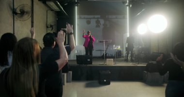 Kilisede ibadete katılan, el kaldıran, dua ve övgüye öncülük eden papaz, Protestan kilisesine ruhsal bağlılık