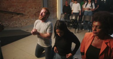 Dinleyiciler ruhani bir çağrıya yanıt olarak Hıristiyan kilisesi etkinliği sırasında kutsanmak için diz çöktüler.