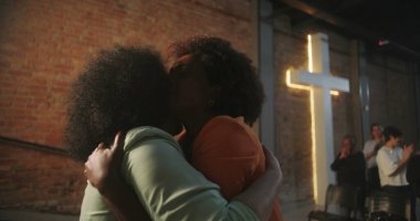 Cemaat üyeleri bir Hıristiyan olayı sırasında duygusal bir kucaklaşmayı paylaşıyorlar, sevgi ve ruhsal bağlantıyı ifade ediyorlar.