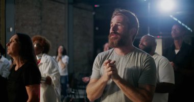 Kilisedeki cemaat ibadetlerini ve inançlarını duayla ifade ediyor. Aydınlanmış haçın yanında el kaldırıyor. Ruhani bir kutlamada birleşiyor.