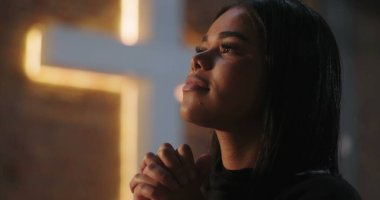 İbadete yukarıdan bakan İspanyol bir kadın. Elleri derin bir yansımayla bağlanmış. Evanjelik kilise ayini sırasında inançla bağlantı kurmuş.