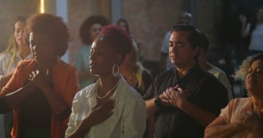 Evanjelist kilise toplantısı sırasında yürekten ibadet eden cemaat, Afrika kökenli vaiz ilham verici bir mesaj, manevi birlik ve bağlılık iletiyor.