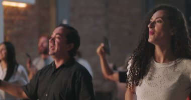 Kilise ayini sırasında zarf sunan çeşitli cemaatler, İspanyol ve Afrikalı Amerikalı bireyler ruhani birlik içinde el kaldırıyor.