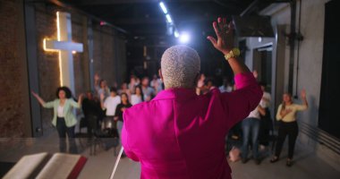 Papaz, ibadet eden ellerini kaldırarak cemaate önderlik ediyor, çeşitli Hıristiyan cemaati modern evanjelik kilisesinde ibadet ve övgüye katılıyor.