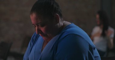 Başı sessizce dua eden, mavi giyen, ruhani yansımaya dalmış ve ibadet sırasında inançla barışçıl bir bağ kuran bir kadın.