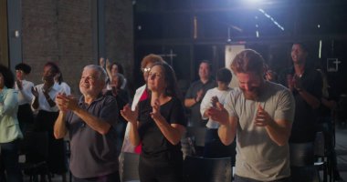 İbadet üstüne ibadet eden cemaat, arka planda parlayan bir haçla kilise ayini sırasında ruhsal bağlantı kuran çeşitli geçmişlere sahip bireyler.