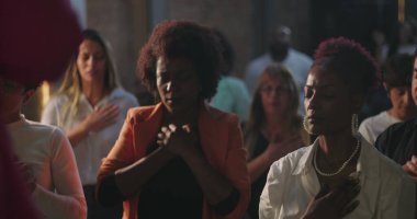 İbadet eden çeşitli Hıristiyan cemaatleri, dua ederken, eller kalplerde, gözler kapalı, evanjelik cemaatte derin ruhsal bağlantı