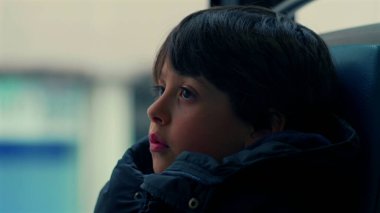 Yakından bakınca, çenesini cekete dayamış, düşünceli bir ifadeyle mesafeye bakan, hareket eden otobüsün içinde, tefekküre dalıp giden manzaraya bakan genç bir çocuğun profili.