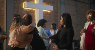 Cemaat üyeleri kilise ortamında gülümsemeleri sıcak bir şekilde kucaklıyor ve paylaşıyor, birlik, inanç ve karşılıklı destek ortamını teşvik ediyorlar.