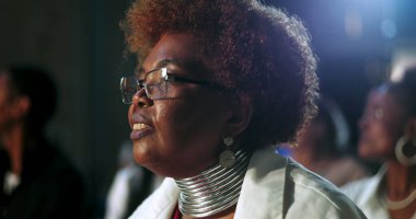 İbadet eden, gözlüklü, yansıtıcı takan ruhani bir kilise toplantısında inanç ve bağlılığını ifade eden bir kadının yakın çekimi.