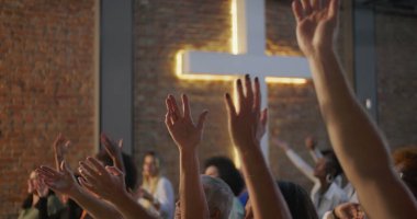 İbadet eden cemaat, çeşitli kişilerin katıldığı ruhani bir kilise toplantısında kutlama ve bağlılık için el kaldırma.