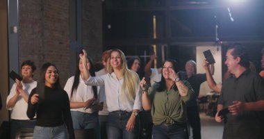 Kiliseye ibadet sırasında bağış kutusuna zarf koyan iki kadın, neşeli ve saygılı ifadeler, ruhani sunuma katılan çeşitli arka planda yer alan farklı topluluk