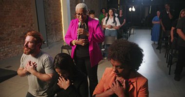 Dinleyiciler ruhani bir çağrıya yanıt olarak Hıristiyan kilisesi etkinliği sırasında kutsanmak için diz çöktüler.