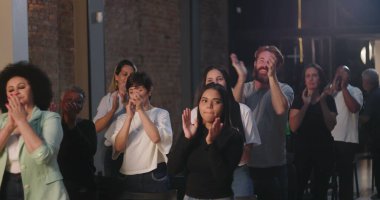 Çeşitli insan grupları ruhani bir toplantıda el çırpıyor, birlik ve inancın sevinçli bir şekilde kutlanıyor, etnik içerikli, ibadet sırasında toplum birbirine bağlanıyor.