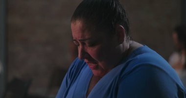 Başı sessizce dua eden, mavi giyen, ruhani yansımaya dalmış ve ibadet sırasında inançla barışçıl bir bağ kuran bir kadın.