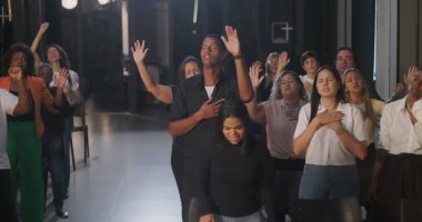 Cemaate hitap eden vaiz yakın plan, yükseltilmiş el ile canlı enerji, kapalı kilise ayarları, ruhsal bağlantı ve grup ibadetleri, duadaki dinamik liderlik