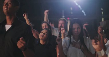 Çeşitli cemaatler duygusal dualar sırasında zarf dağıtıyor, tapınmaya dalmış ve derin ruhsal yansımaya dalmış.
