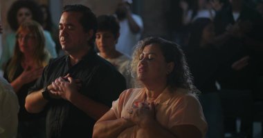 Evanjelist kilise toplantısı sırasında yürekten ibadet eden cemaat, Afrika kökenli vaiz ilham verici bir mesaj, manevi birlik ve bağlılık iletiyor.