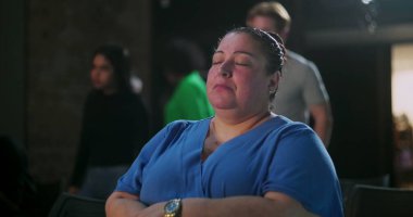 Orta yaşlı, gözleri kapalı oturan Latin bir kadın dingin bir ortamda ruhani bir toplantı sırasında derin bir yansıma ve huzur içinde dua etmeye dalmış.