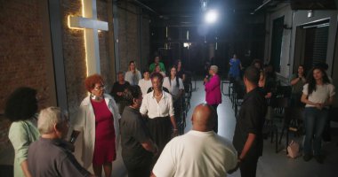 Dua ve ibadete katılan cemaat, ruhani bağlantılara odaklanmış, modern evanjelik kilise ortamında lider rehberlik hizmeti