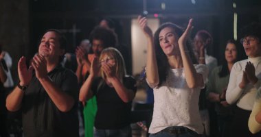 Çeşitli insan grupları ruhani bir toplantıda el çırpıyor, birlik ve inancın sevinçli bir şekilde kutlanıyor, etnik içerikli, ibadet sırasında toplum birbirine bağlanıyor.