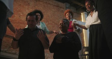 Cemaat ibadete katılıyor, ruhani bağlantıda el ele tutuşuyor, kilise ayini sırasında liderin rehberliğinde, cemaatin önünde modern evanjelik ibadeti yapıyor.