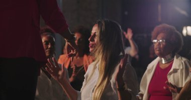 Vaiz, dua ederken ellerini kaldırmış bir kadını kutsar. Çeşitli cemaatlerle çevrili derin bir duygusal dua anı. Ruhlar aleminde kutsal bir atmosfer.