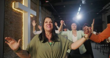 İbadet sırasında el ele tutuşan, birlik ve neşe ifade eden insanlar, inanç ve toplumu ruhani ve canlandırıcı bir ortamda sembolize eden çapraz ışık.