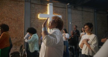 İbadet eden çeşitli cemaatler, kalpleri teslim eden ve övgüyle yükselen, arka planda parlayan haç, kollektif ruhsal bağlantı, birlik ve kutsal kilise hizmetine olan inanç.