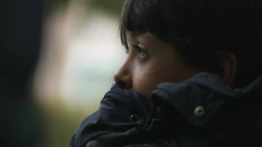 Yakından bakınca, çenesini cekete dayamış, düşünceli bir ifadeyle mesafeye bakan, hareket eden otobüsün içinde, tefekküre dalıp giden manzaraya bakan genç bir çocuğun profili.