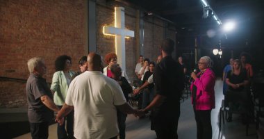 Kilise ayini sırasında el ele tutuşan bir grup insan, ruhani lider, inanç ve ibadetle birleşmiş cemaat, evanjelik Hıristiyan ibadeti