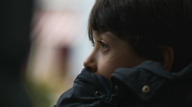 Yakından bakınca, çenesini cekete dayamış, düşünceli bir ifadeyle mesafeye bakan, hareket eden otobüsün içinde, tefekküre dalıp giden manzaraya bakan genç bir çocuğun profili.