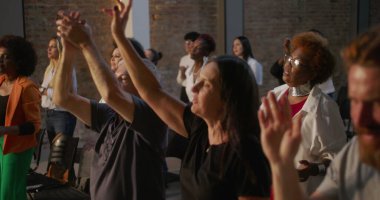 İbadet eden cemaat, çeşitli kişilerin katıldığı ruhani bir kilise toplantısında kutlama ve bağlılık için el kaldırma.