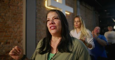 Kilisede ibadet ederken Latin kökenli duygusal bir kadın, tapınmadan büyülenmiş, arka planda aydınlanmış, ruhsal bağlılık ve içtenlikle bağlanmış.