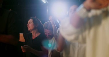 Cemaatler ruhani birlik içinde alkışlıyor. Evanjelik kilise ayini sırasında inancı kutlayan karışık bir grup insan el çırpıyor. İbadet ifadeleri ve adanmışlık.