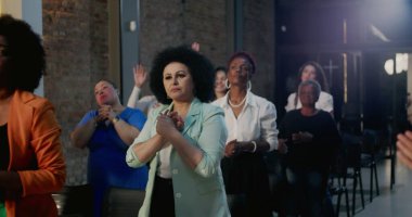 Çeşitli insanlar ruhani ibadet sırasında tutkuyla dua eder modern bir kilisede toplanır, yürekten bir atmosferde inanç ve bağlılıklarını ifade ederler.