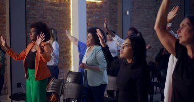 Kilisede ruhani bir toplantı sırasında insanlar el kaldırıyor. İnançlarını, bağlılıklarını ve birlikteliklerini yürekten bir duayla ifade ediyorlar.