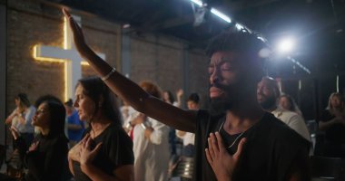 Afrika kökenli Amerikalı bir adam, el kaldırılmış ve kalpten bağlanmış, arka planda parlayan, derin ruhsal bağlantı, inanç ve kutsal kilise hizmetinde birlik.