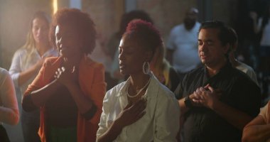 Evanjelist kilise toplantısı sırasında yürekten ibadet eden cemaat, Afrika kökenli vaiz ilham verici bir mesaj, manevi birlik ve bağlılık iletiyor.