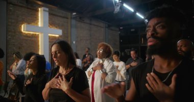 Çeşitli tapınma grupları, kalpte eller, arka planda parlayan haç, kolektif ruhsal bağlantı, yürekten inanç ve kutsal kilisede birlik.