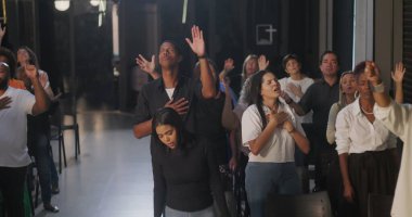 Cemaate hitap eden vaiz yakın plan, yükseltilmiş el ile canlı enerji, kapalı kilise ayarları, ruhsal bağlantı ve grup ibadetleri, duadaki dinamik liderlik