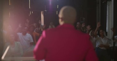 Afrika kökenli bir kadın vaaz verirken cemaat ibadete daldı. Evanjelik kilise toplantısı sırasında, övgüler ve bağlılıkla el kaldırıldı.