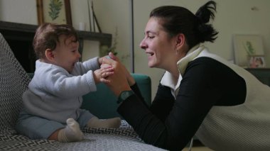 Anne bebeği bağlamak için nesne tutuyor, duyusal keşif ve odaklanmayı teşvik ediyor, destekleyici bir ev ortamında oyun zamanı etkileşimini teşvik ediyor, erken çocukluk öğrenimini destekliyor..