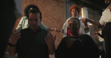 Cemaat ibadete katılıyor, ruhani bağlantıda el ele tutuşuyor, kilise ayini sırasında liderin rehberliğinde, cemaatin önünde modern evanjelik ibadeti yapıyor.